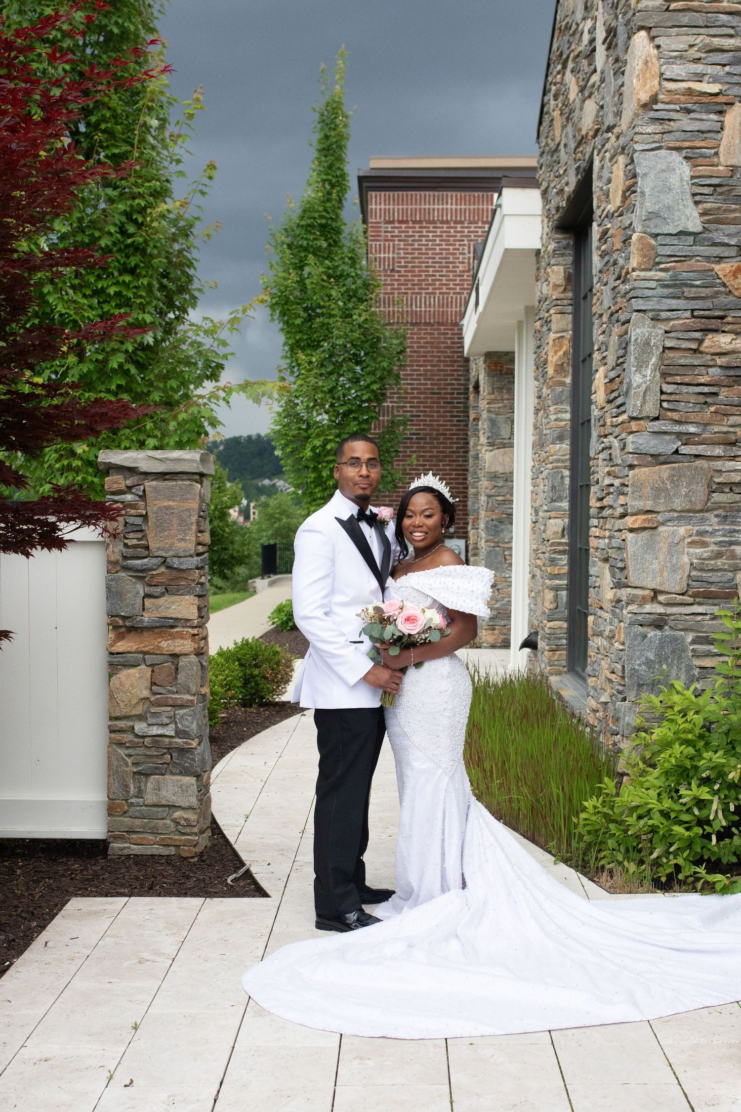 Wedding photography session on stone pathway with dramatic train of white dress.