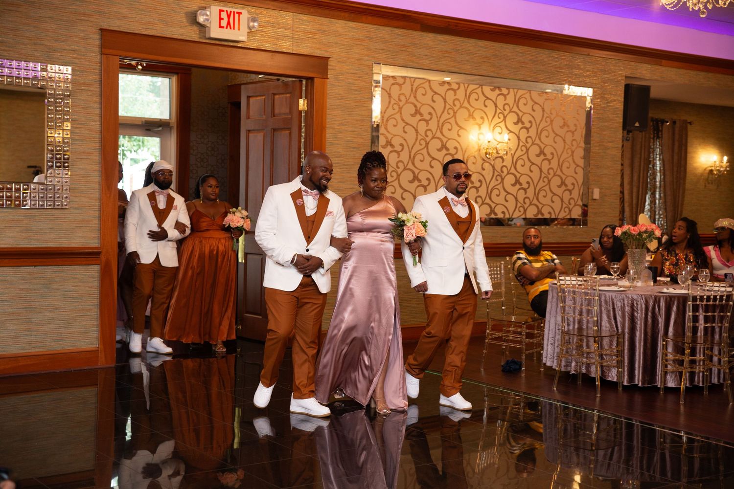 Wedding celebration in a luxurious banquet hall with dramatic purple lighting and chandeliers.