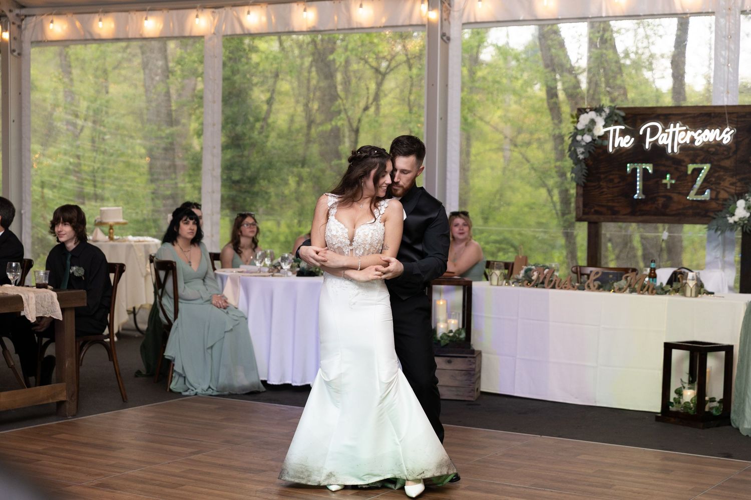 Bride and groom share their first dance at The Pattersons wedding reception in an elegant glass venue.