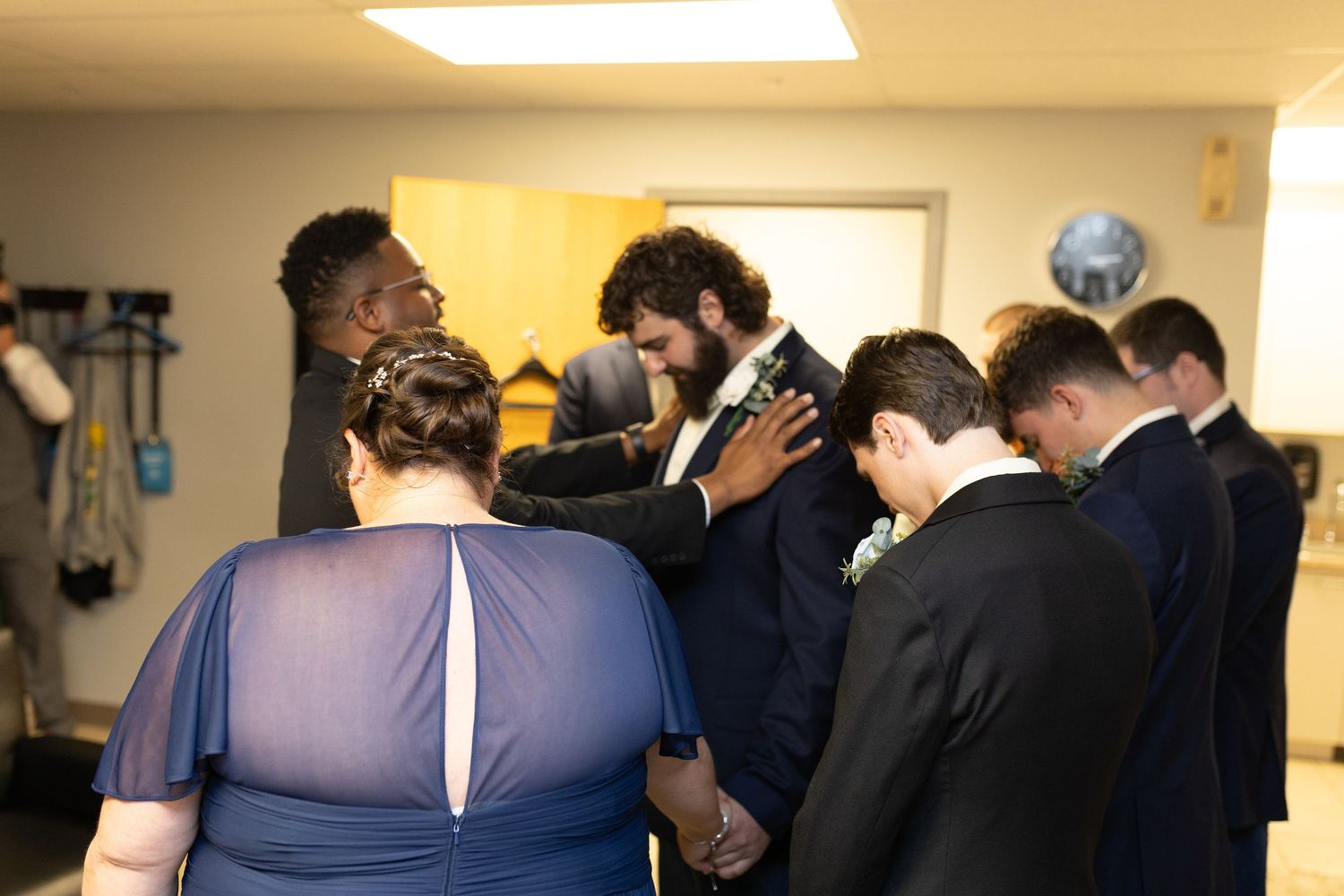 Wedding party members gathered in an indoor venue before the ceremony.