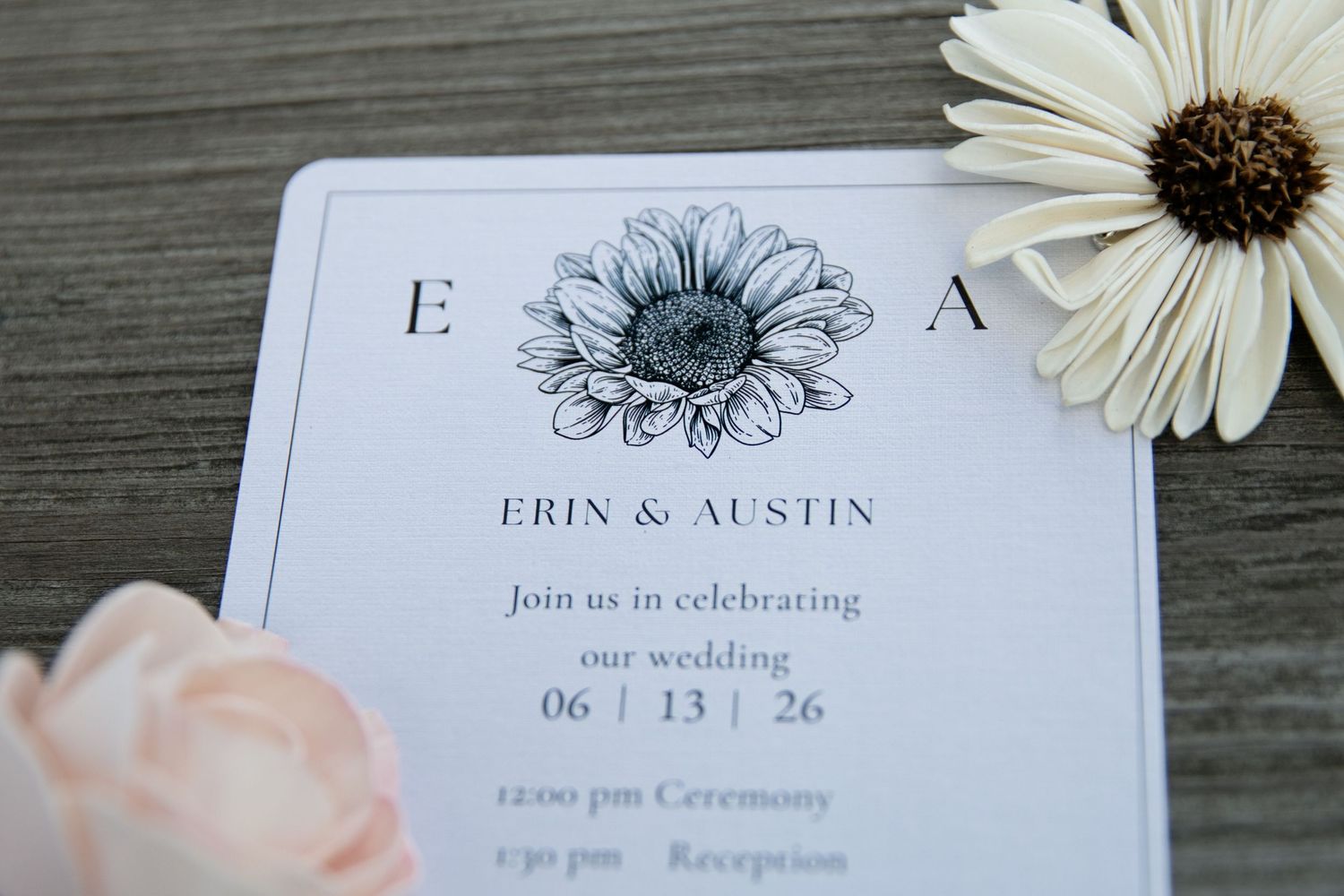 Elegant wedding invitation for Erin and Austin dated 06/13/26, featuring a floral illustration, beside white and pink flowers.