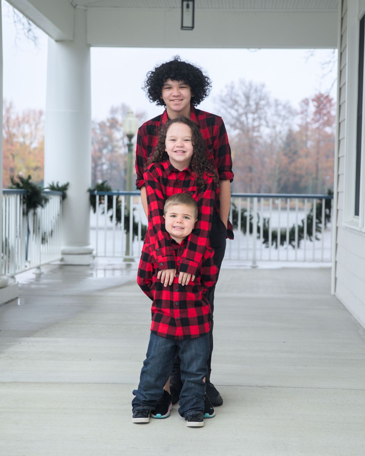 Candid family moments captured on an elegant white porch during fall season.