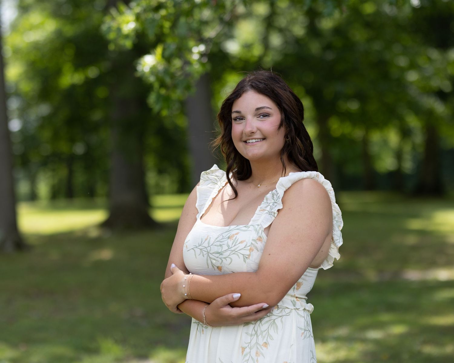 A white eyelet dress stands out against a lush green summer park backdrop.