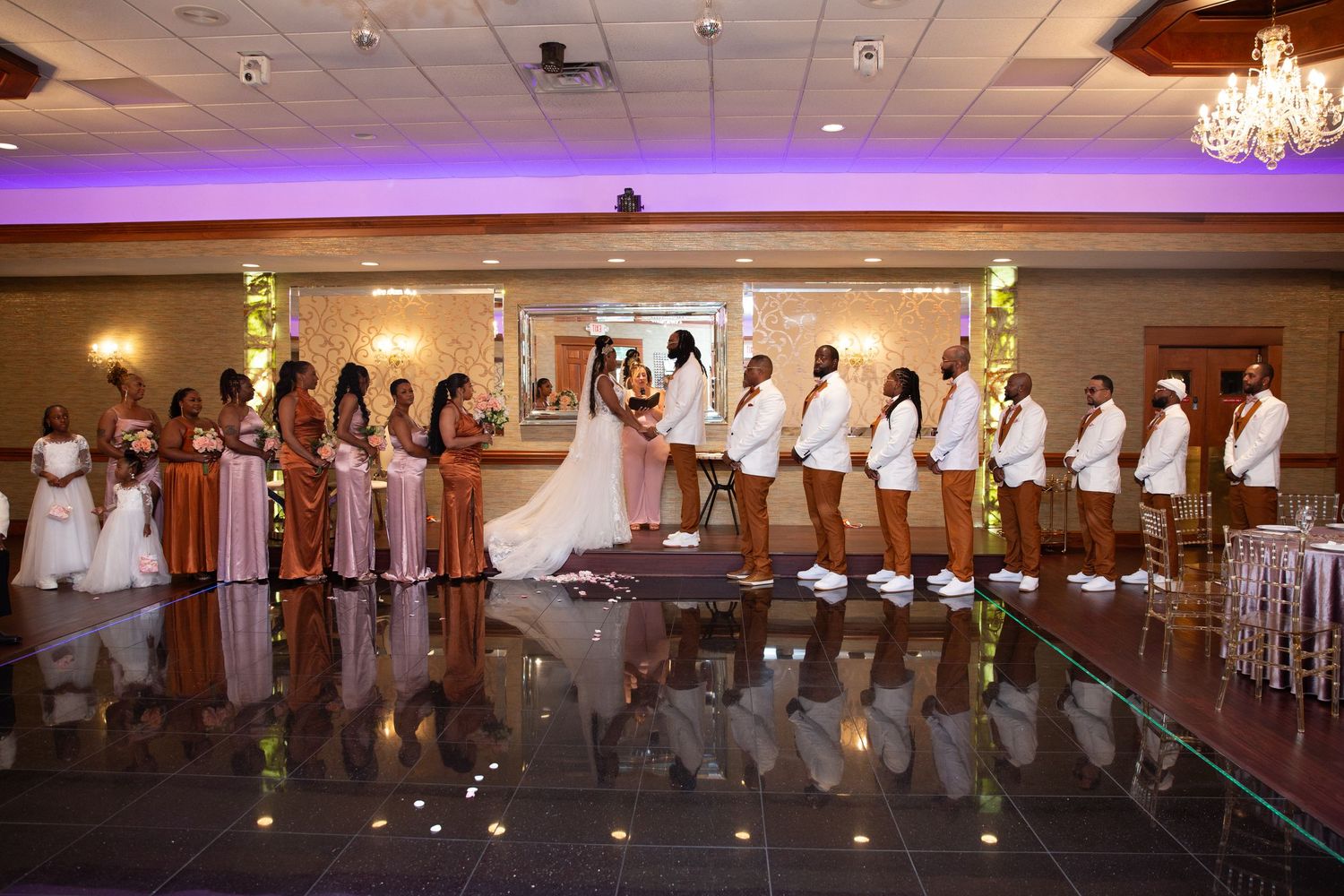 Wedding party members perform a choreographed dance routine in an elegant reception hall.