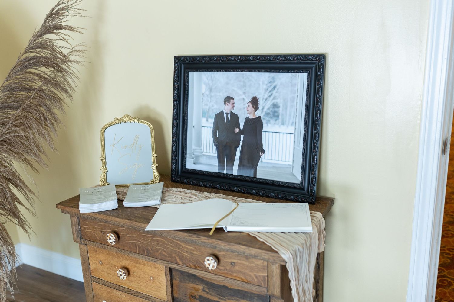 A vintage-style dresser with mirror and framed photograph display in rustic decor setting.