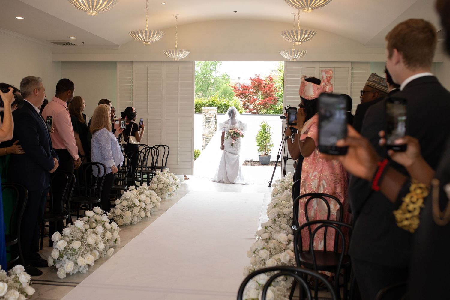Wedding ceremony venue with bright windows and elegant white floral arrangements.