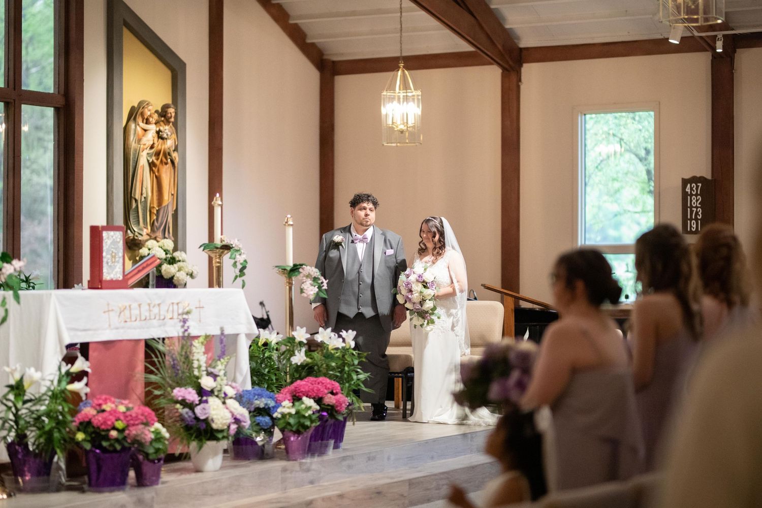 Bride and groom standing at the altar of a decorated chapel during a wedding ceremony.