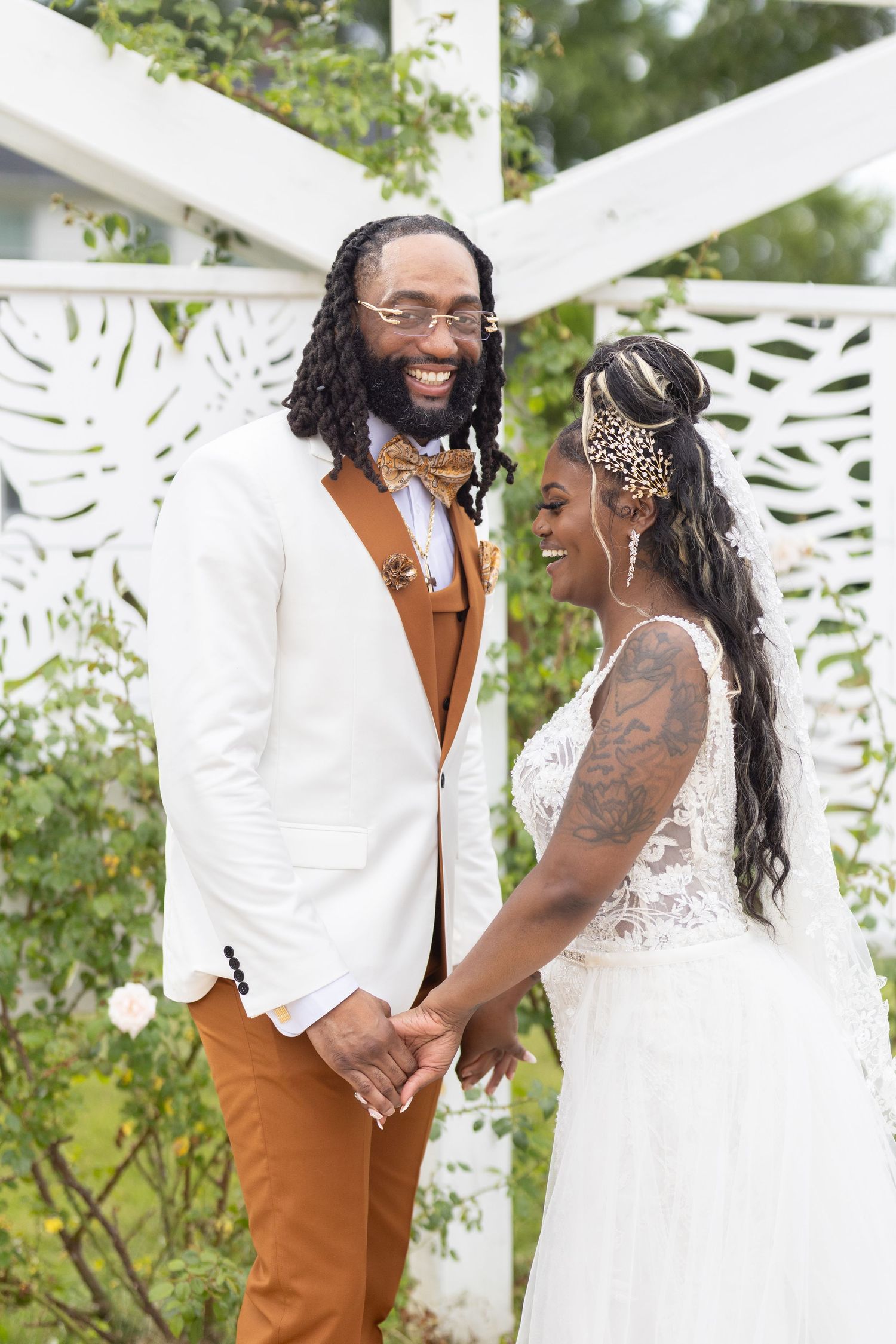 Couple shares joyful moment during wedding under white pergola.