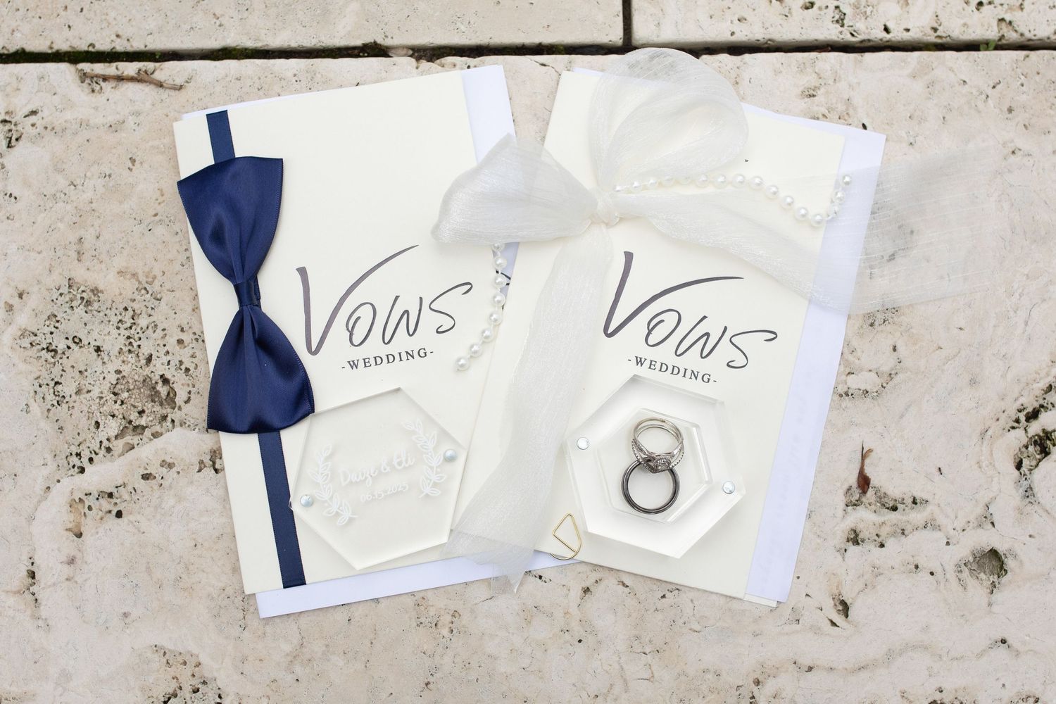 Wedding vow cards and blue accents arranged on textured white surface.