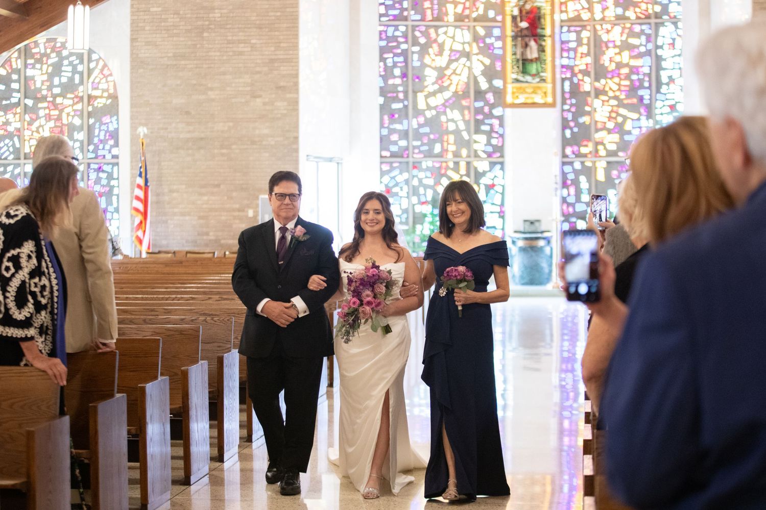 Church sanctuary with stained glass windows during wedding ceremony.