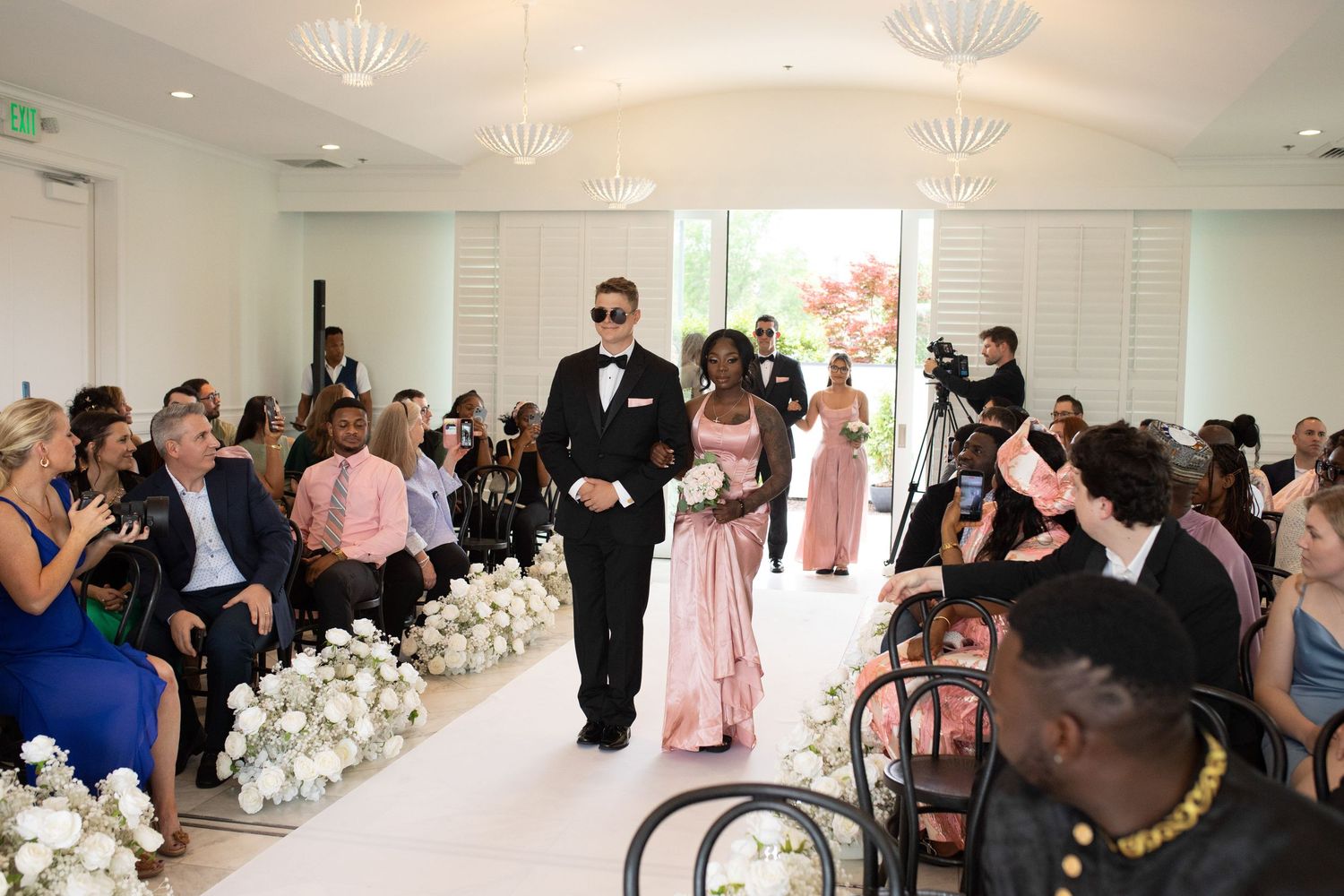 Elegant wedding ceremony space with crystal chandeliers and rows of guest seating.