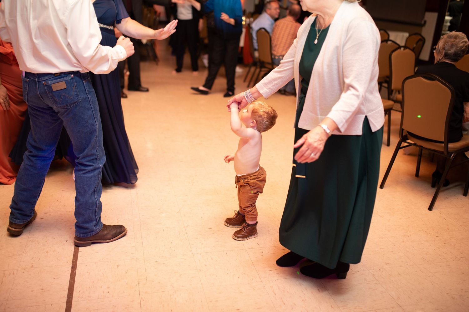 Wedding guests dancing in casual attire at an evening reception.