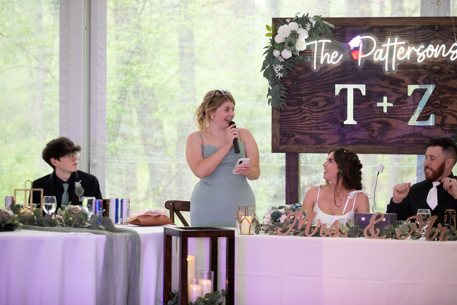 Woman giving a speech at the Patterson wedding reception, with T+Z monogram sign in the background.