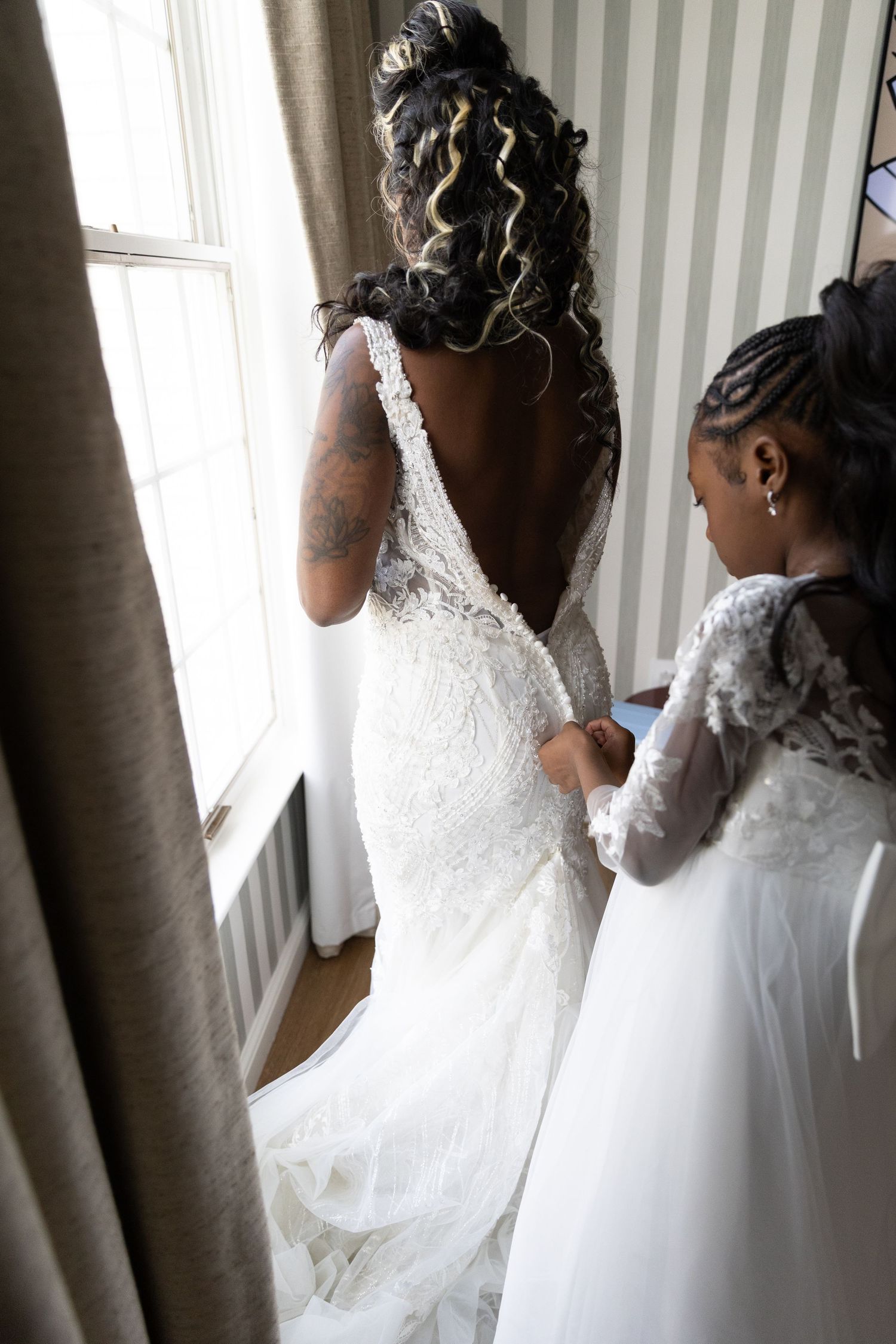 White wedding dresses photographed near a window with natural light.
