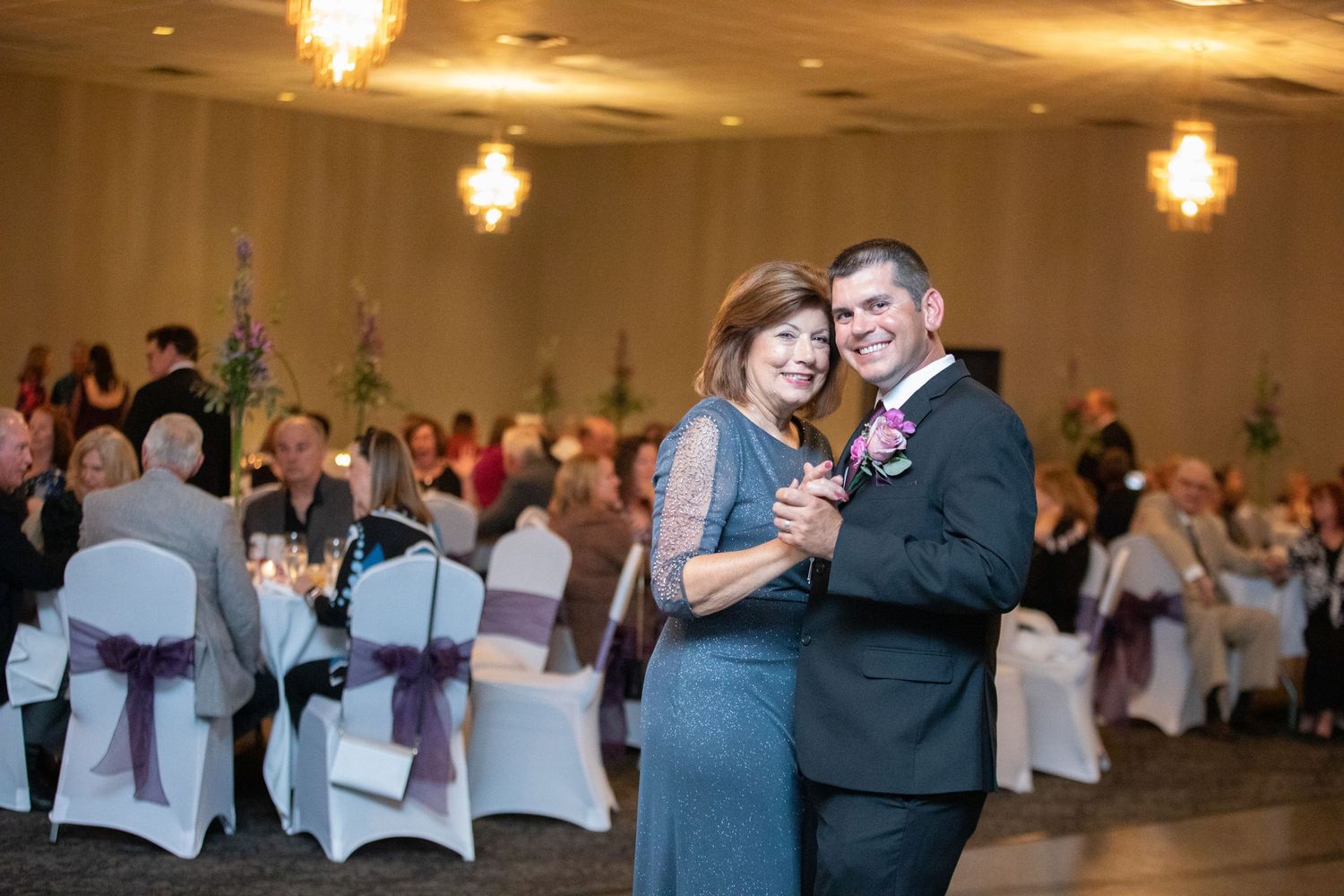 Couples dancing together on the ballroom floor during an elegant wedding reception.