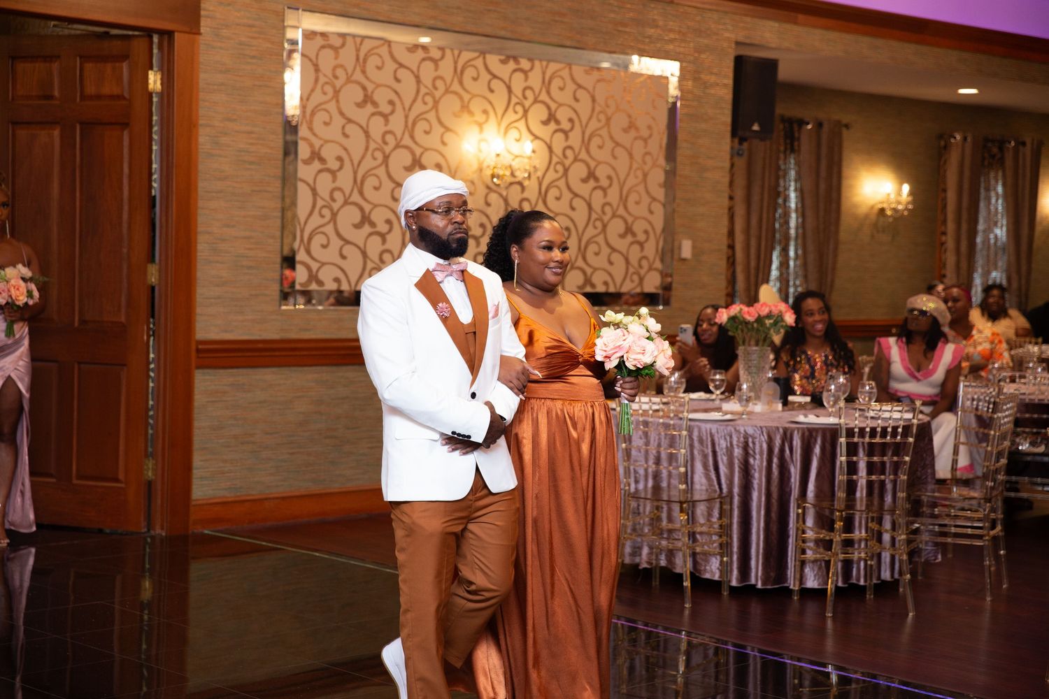 Couples dancing at a formal event in an upscale ballroom with mood lighting.