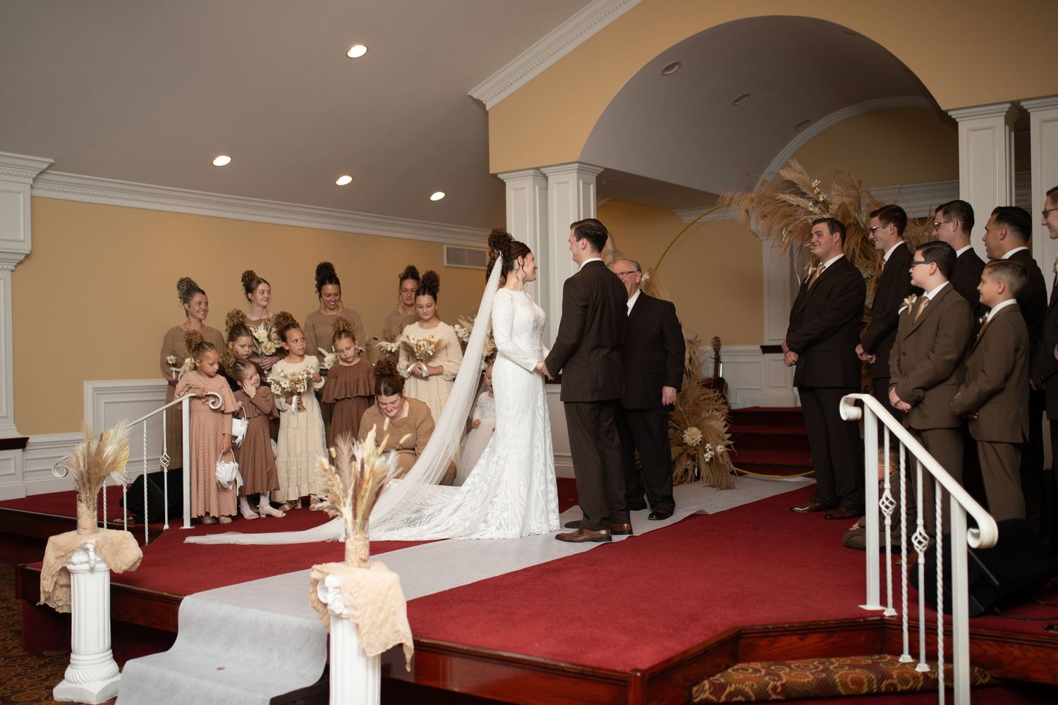 Wedding ceremony space with arched doorways and red carpet leading to the altar area.