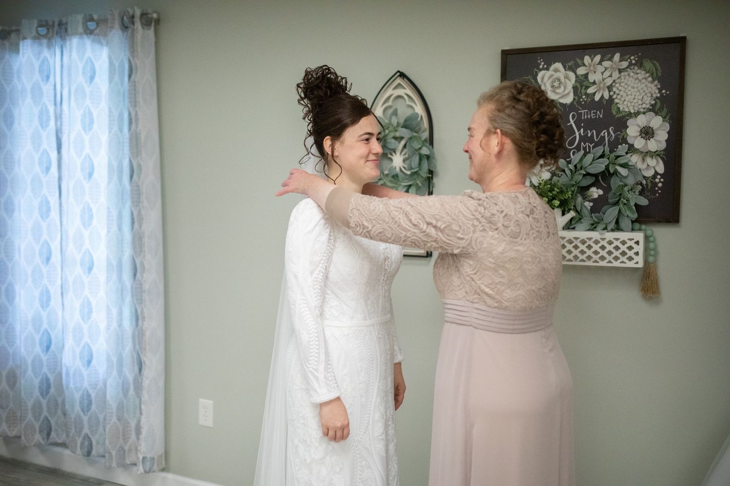 Two people share an emotional moment while making final preparations in a wedding dress.