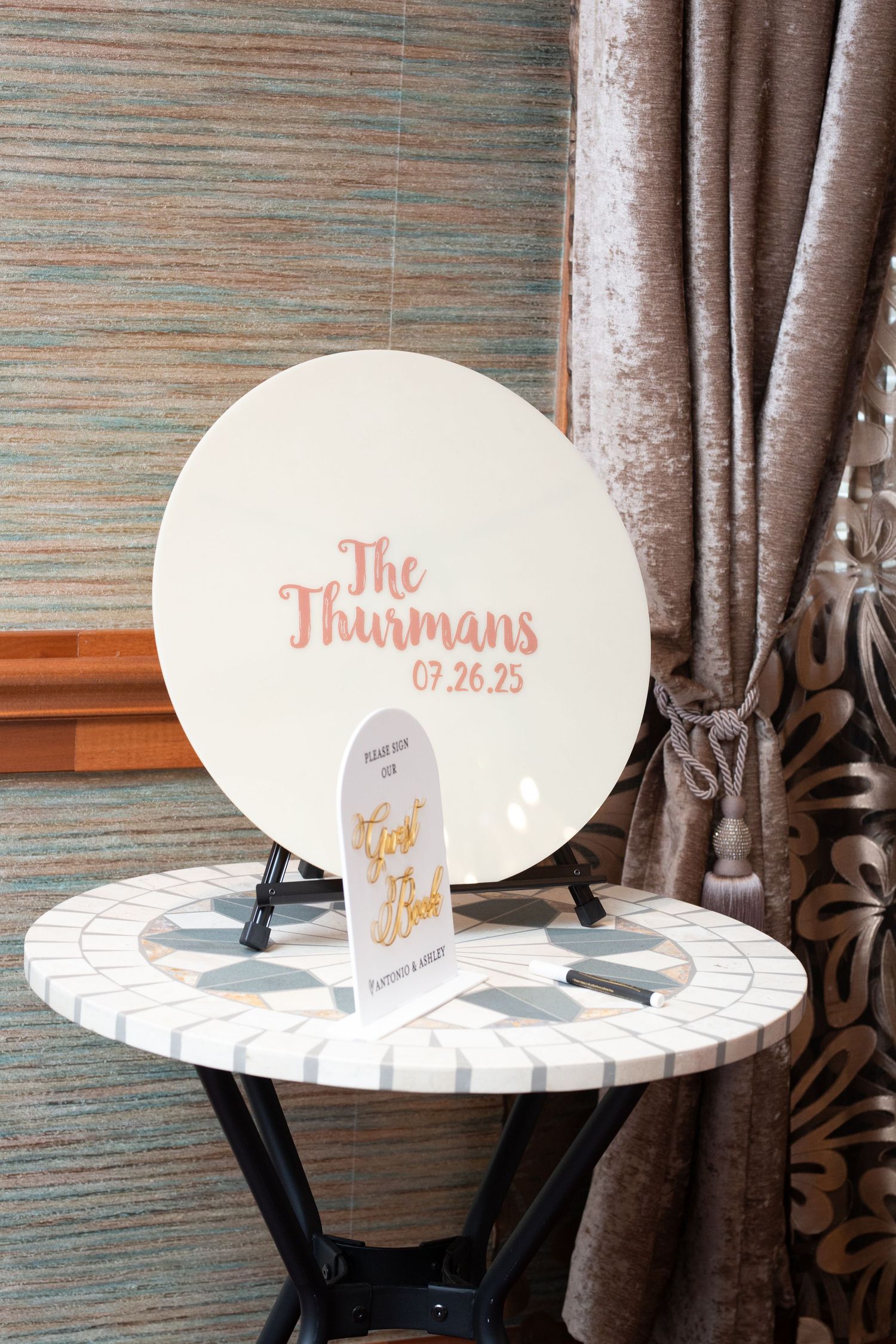 Elegant white decorative signage with personalized text displayed on a stand against a textured wall.