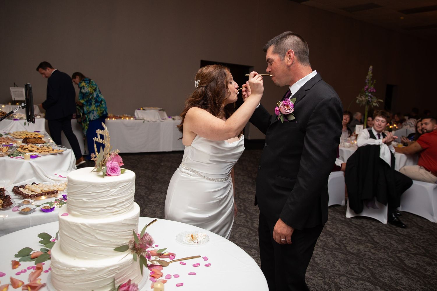 Close-up view of wedding cake cutting moment at reception.