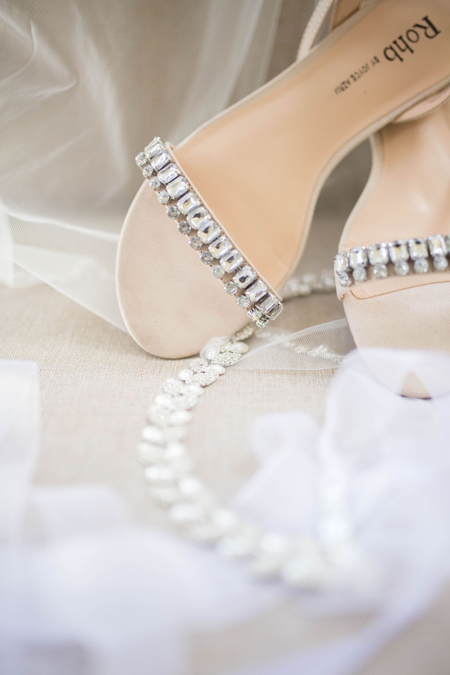 Elegant bridal shoe with crystal embellishments and delicate veil details.