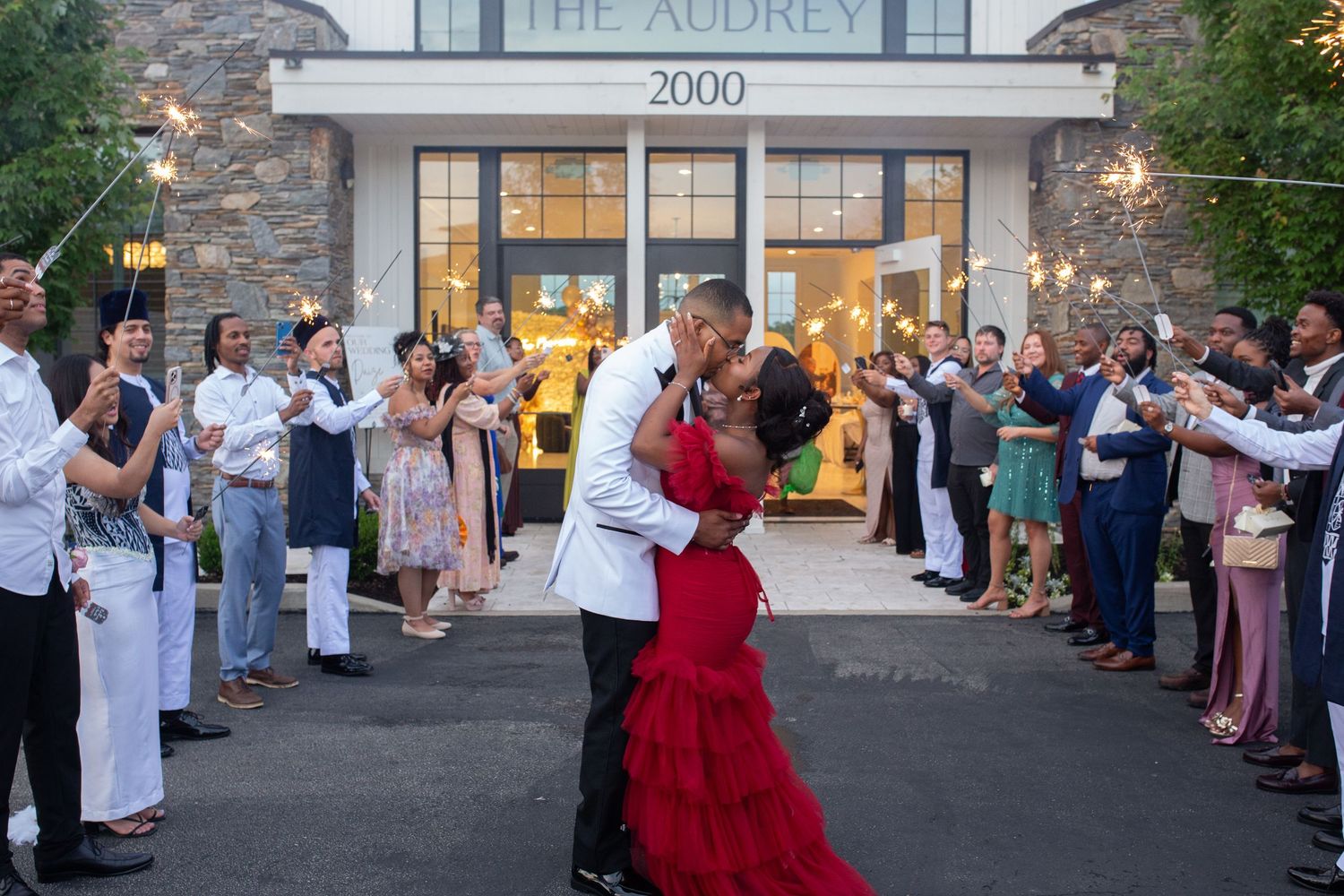 Wedding guests line up outside The Audrey venue to celebrate with the newlyweds during a sparkler send-off.