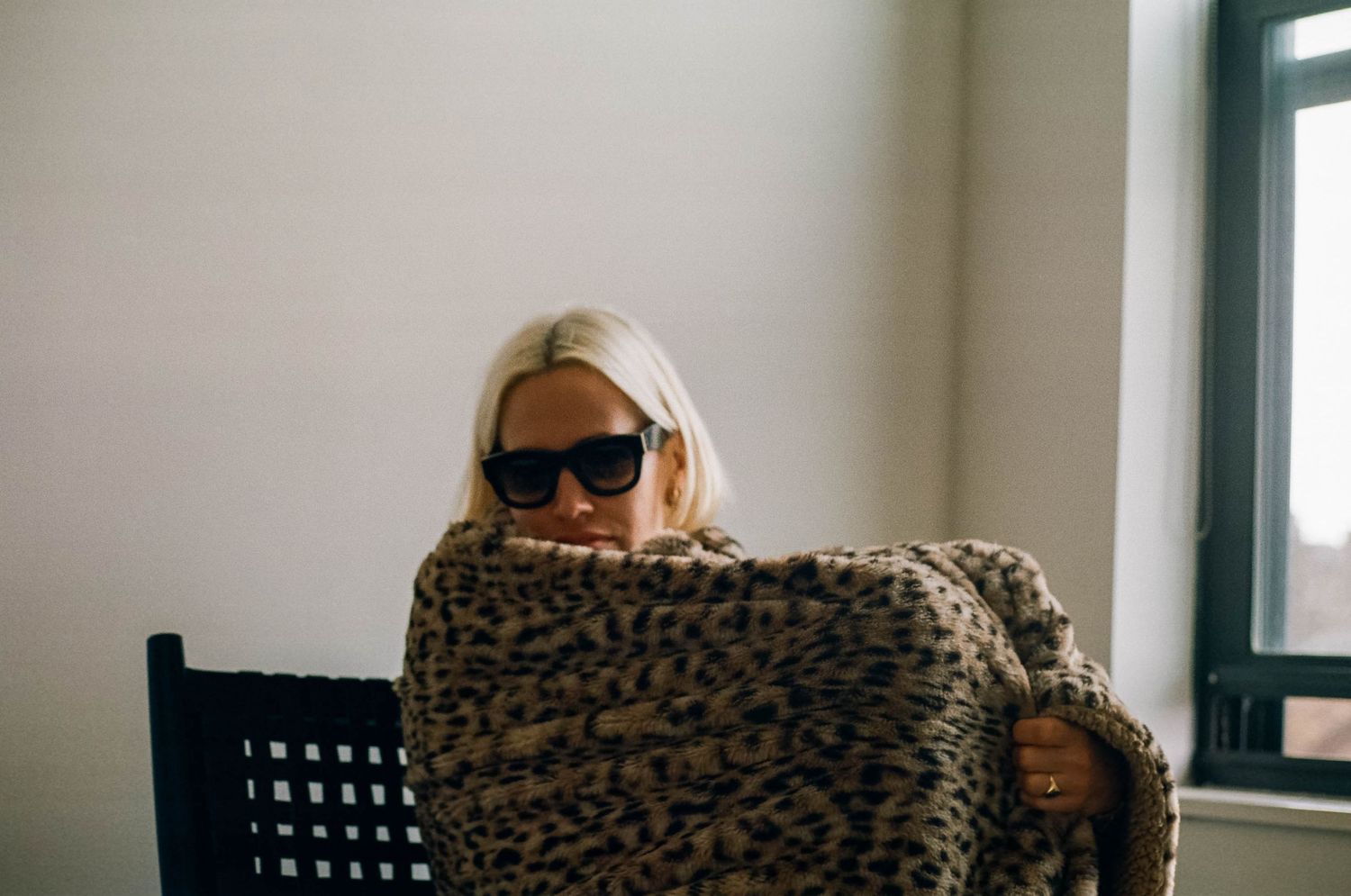 chic woman by window on film sunglasses nyc