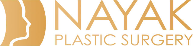 Gold logo for Nayak Plastic Surgery featuring a stylized face profile silhouette beside bold text.