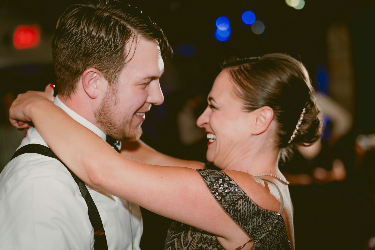 Joyful couple sharing a dance and laughing together at a festive evening reception.
