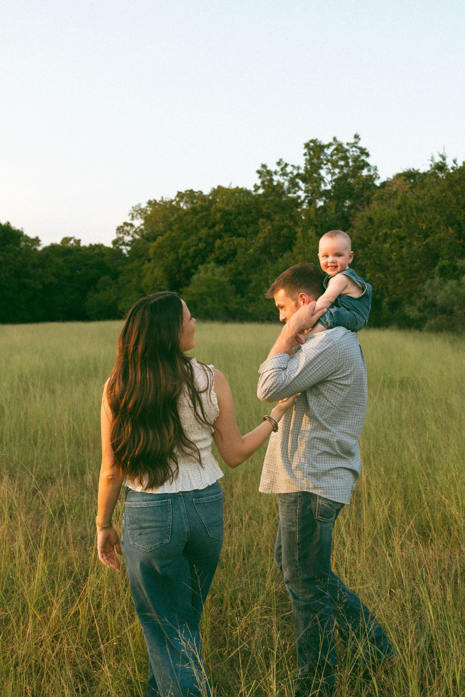 A playful sequence in a grassy field during golden hour.