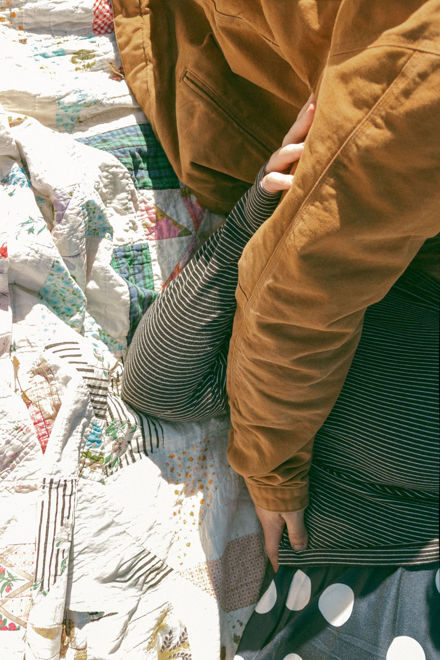 Close-up sequence of someone wearing brown work gloves and striped shirt painting with white paint on a textured surface.