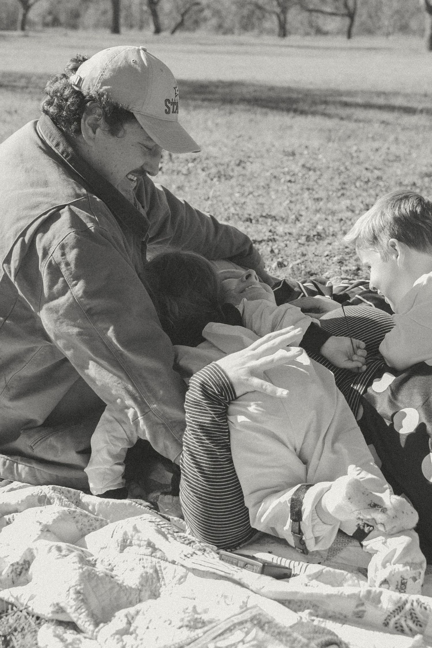 A black and white photo sequence shows people lying on blankets in a grassy outdoor setting.
