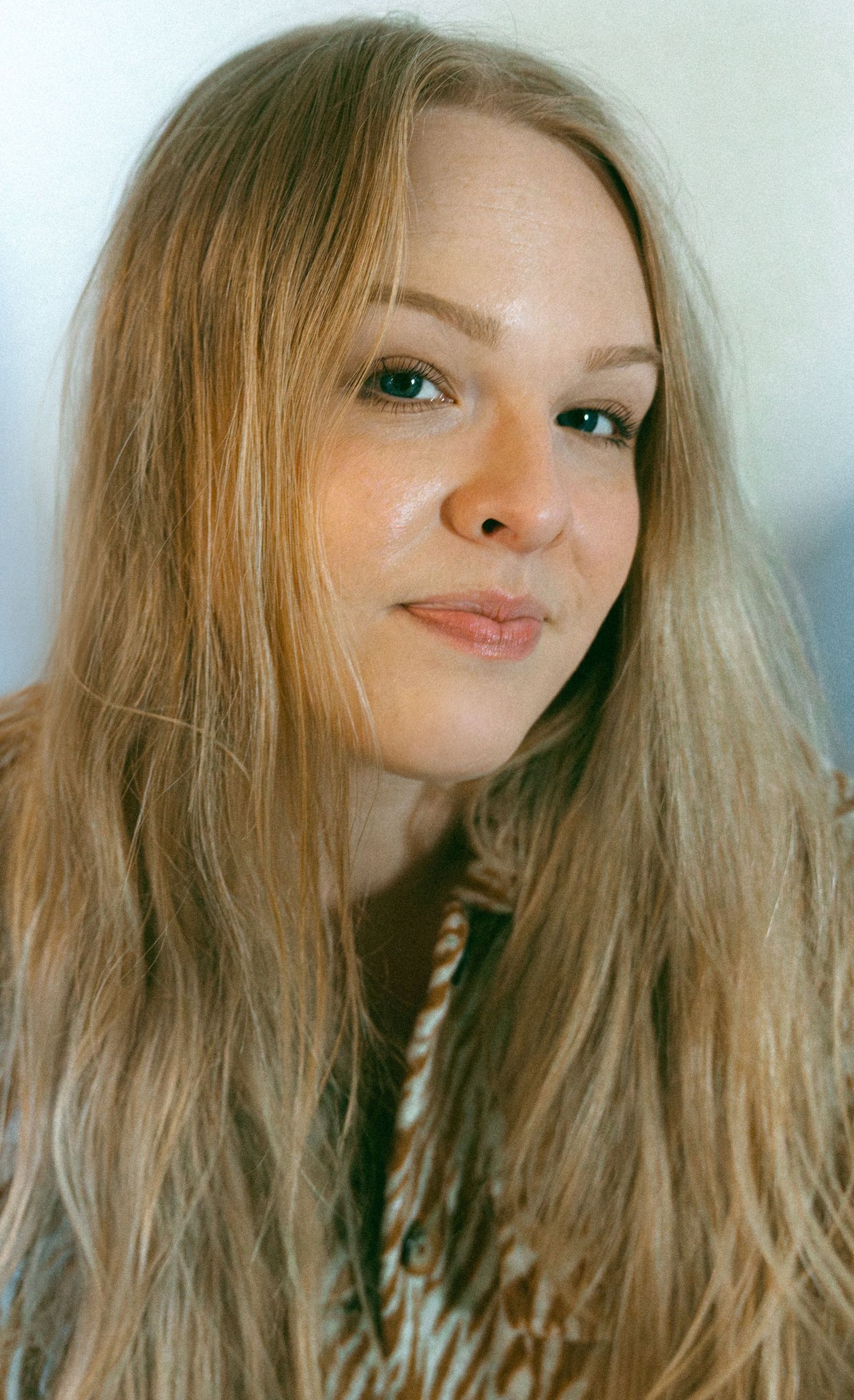 A series of five close-up portrait shots showing blonde hair and green eyes in dreamy, soft lighting.