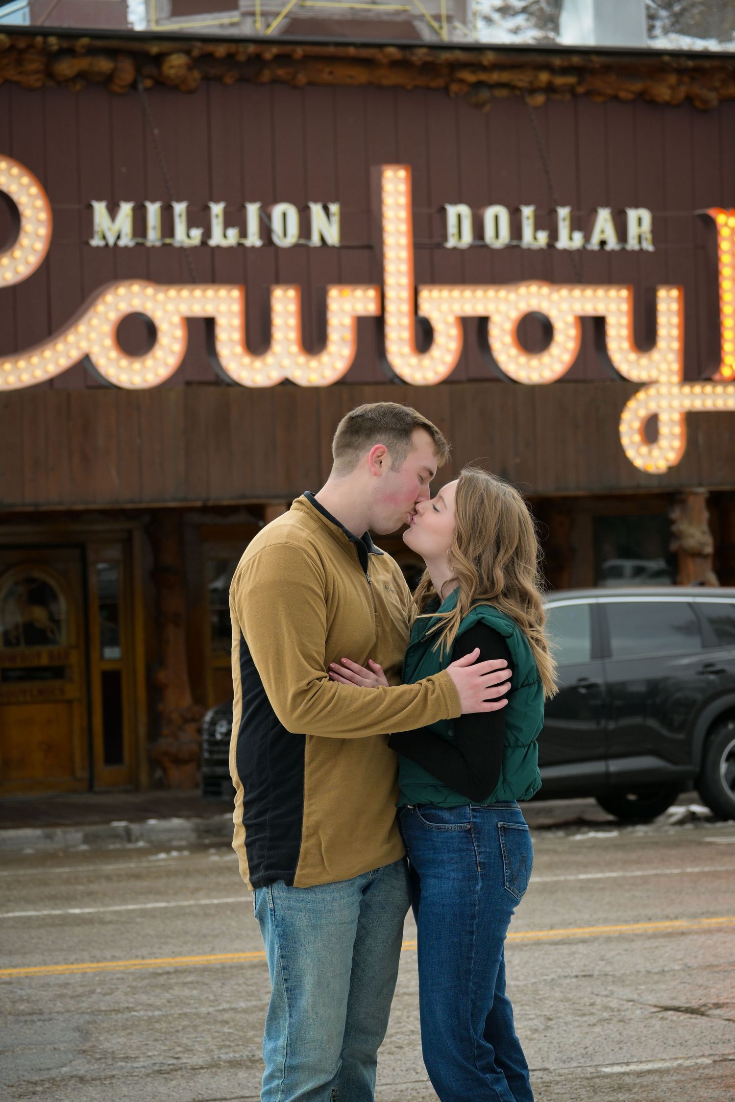 Couple sharing a romantic moment outside the Million Dollar Cowboy sign.