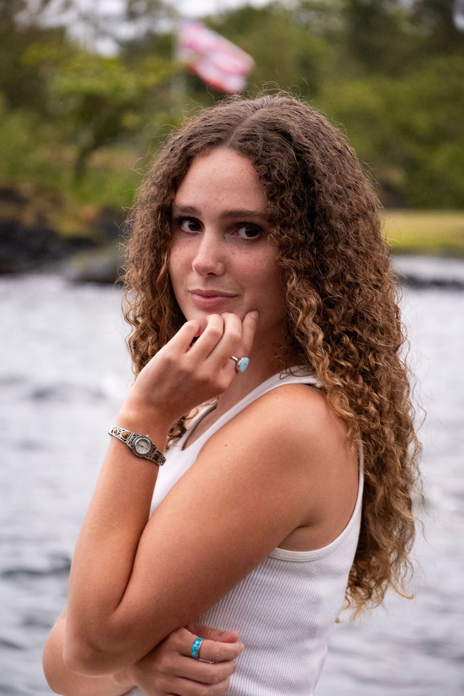 A series of portrait shots showing someone with curly hair posing expressively against a waterfront background.