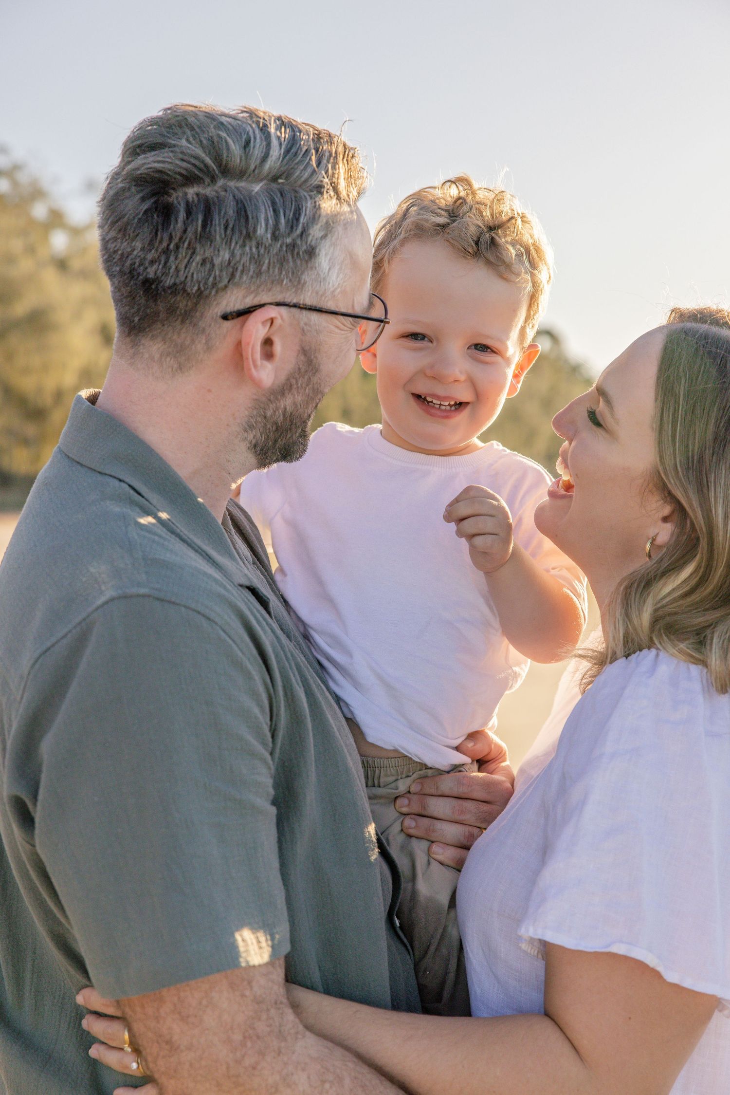 A couple embraces and shares joyful moments together during a golden hour photoshoot outdoors.