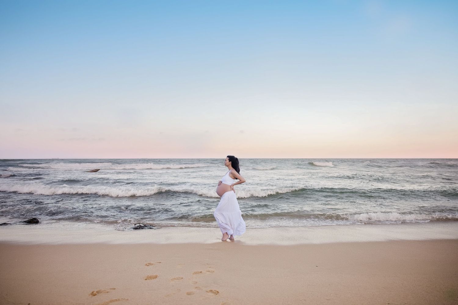 A collection of dreamy beach wedding photos showing a couple in white against the ocean at sunset.