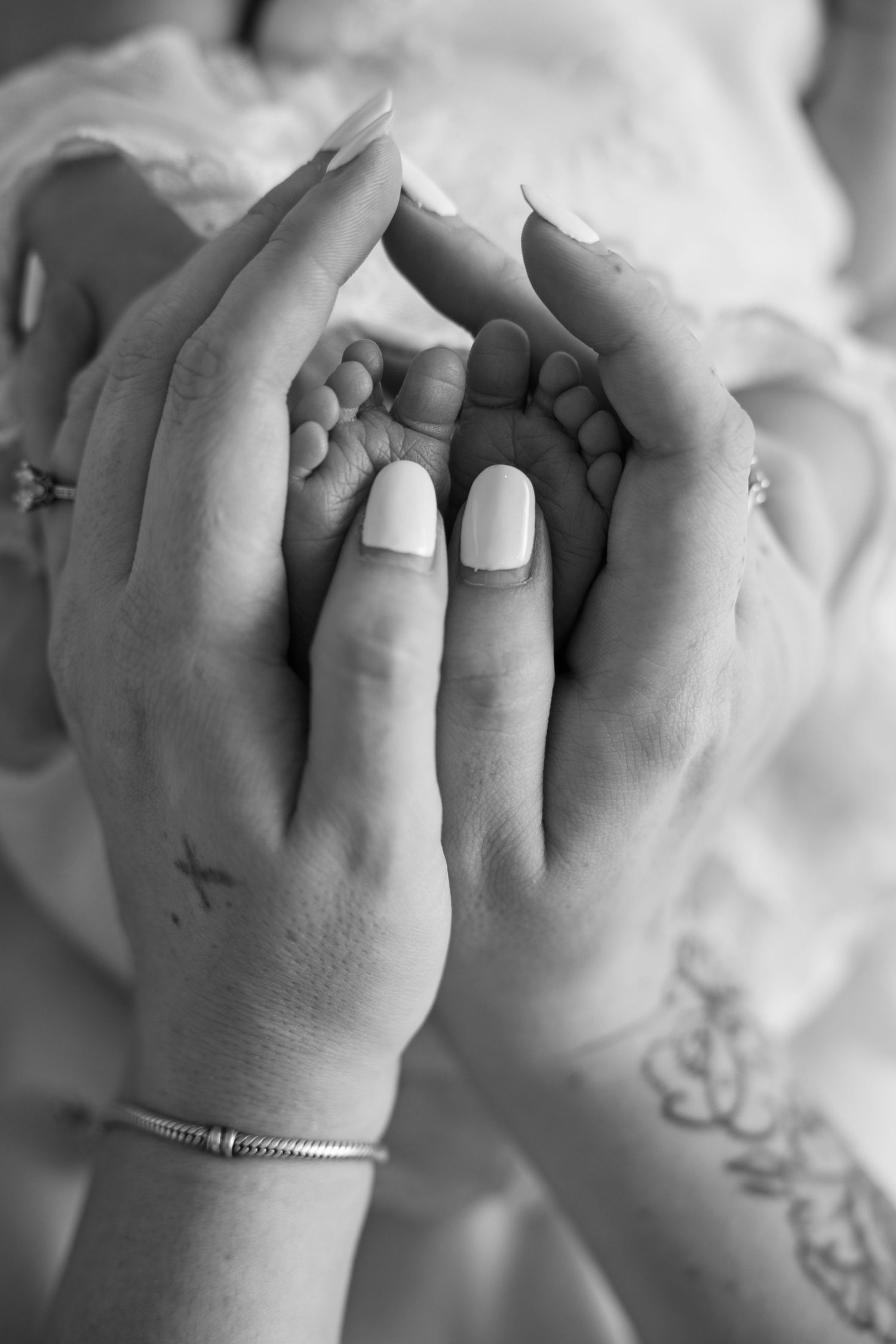 A series of black and white photographs showing intertwined hands with a delicate bracelet detail.