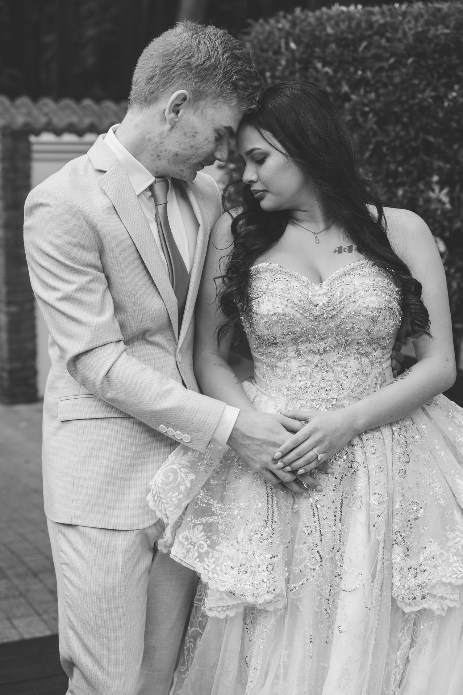 A romantic black and white wedding photo series shows tender moments between a couple, with the bride in a sparkling gown.