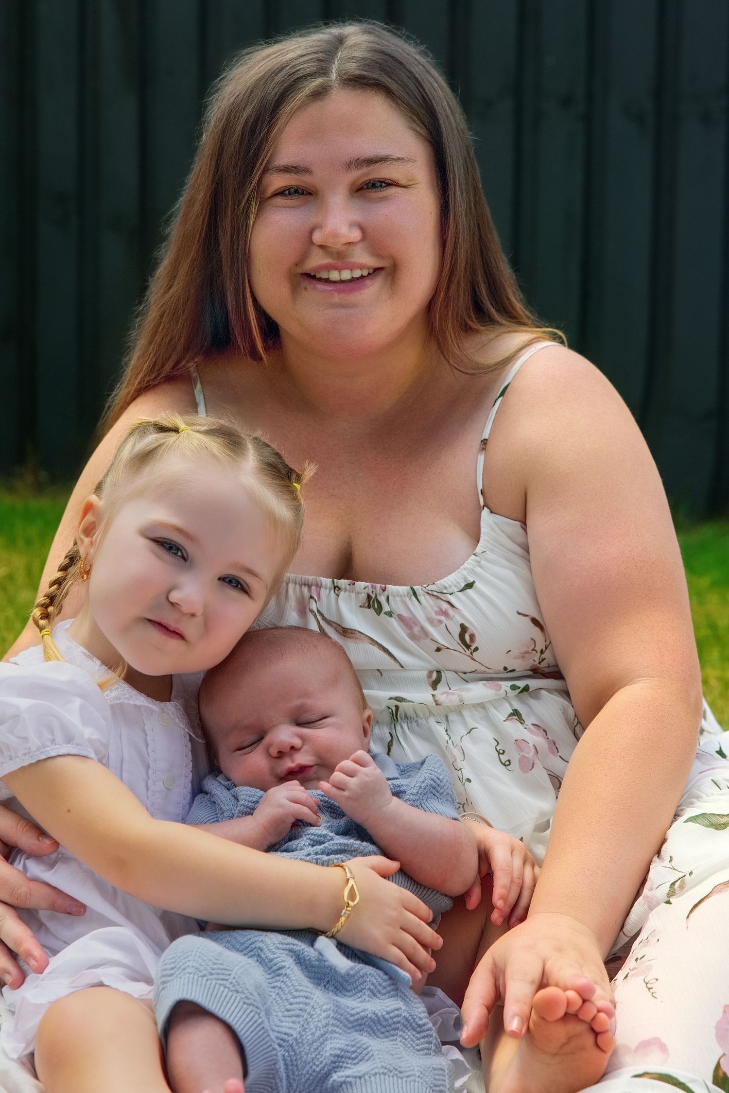A sweet family portrait series showing tender moments between a mother and her children outdoors on a sunny day.