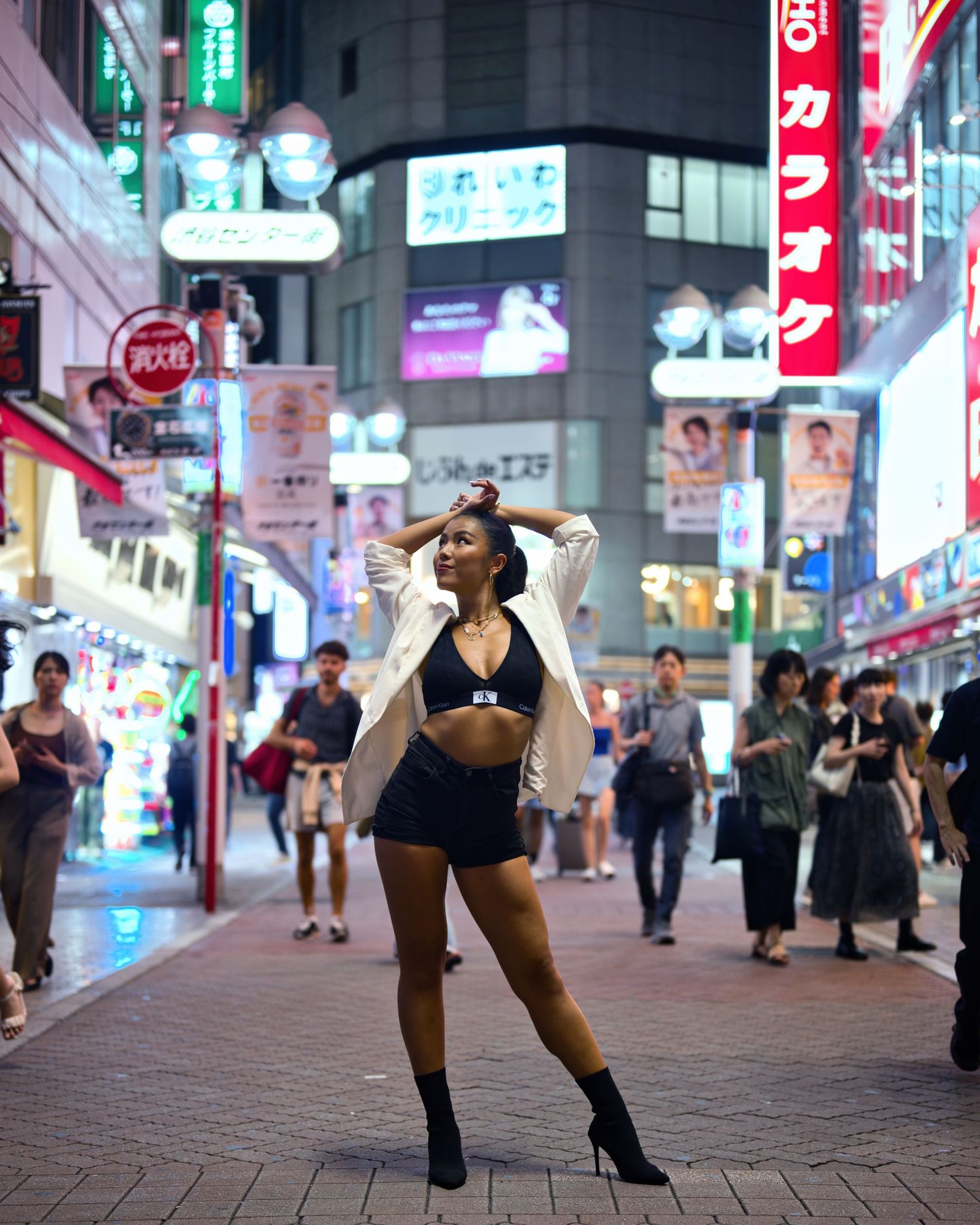 A stylish street fashion pose against vibrant neon city lights in Tokyo.