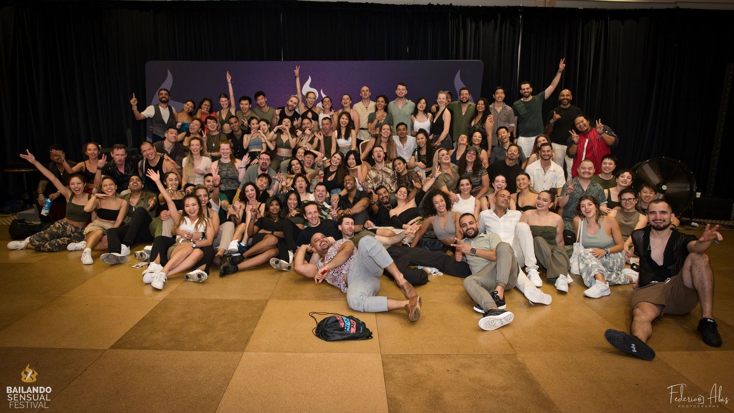 Large group of dancers posing together on stage during a performance event.