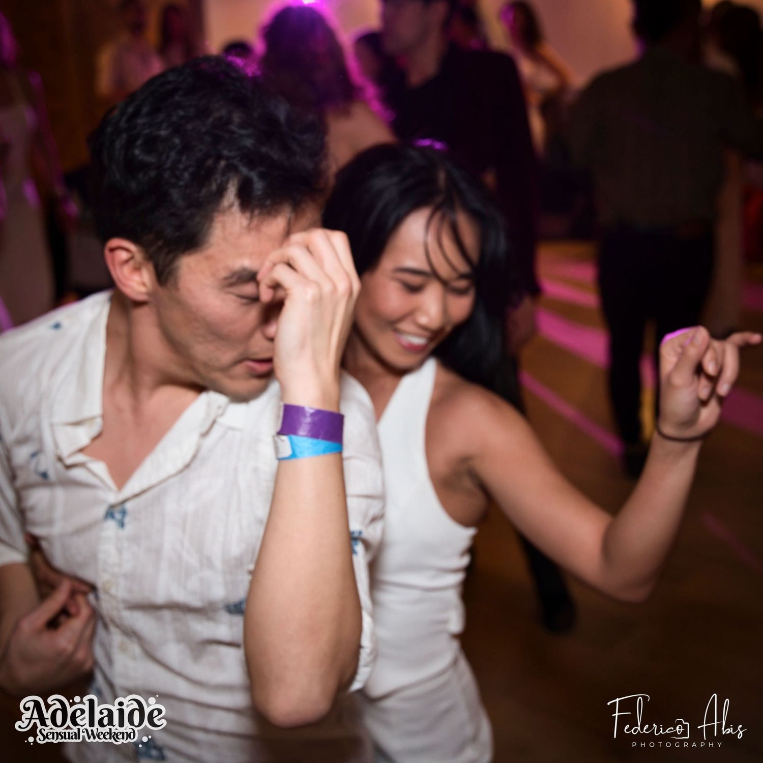 Two dancers expressing themselves energetically at a dance party.