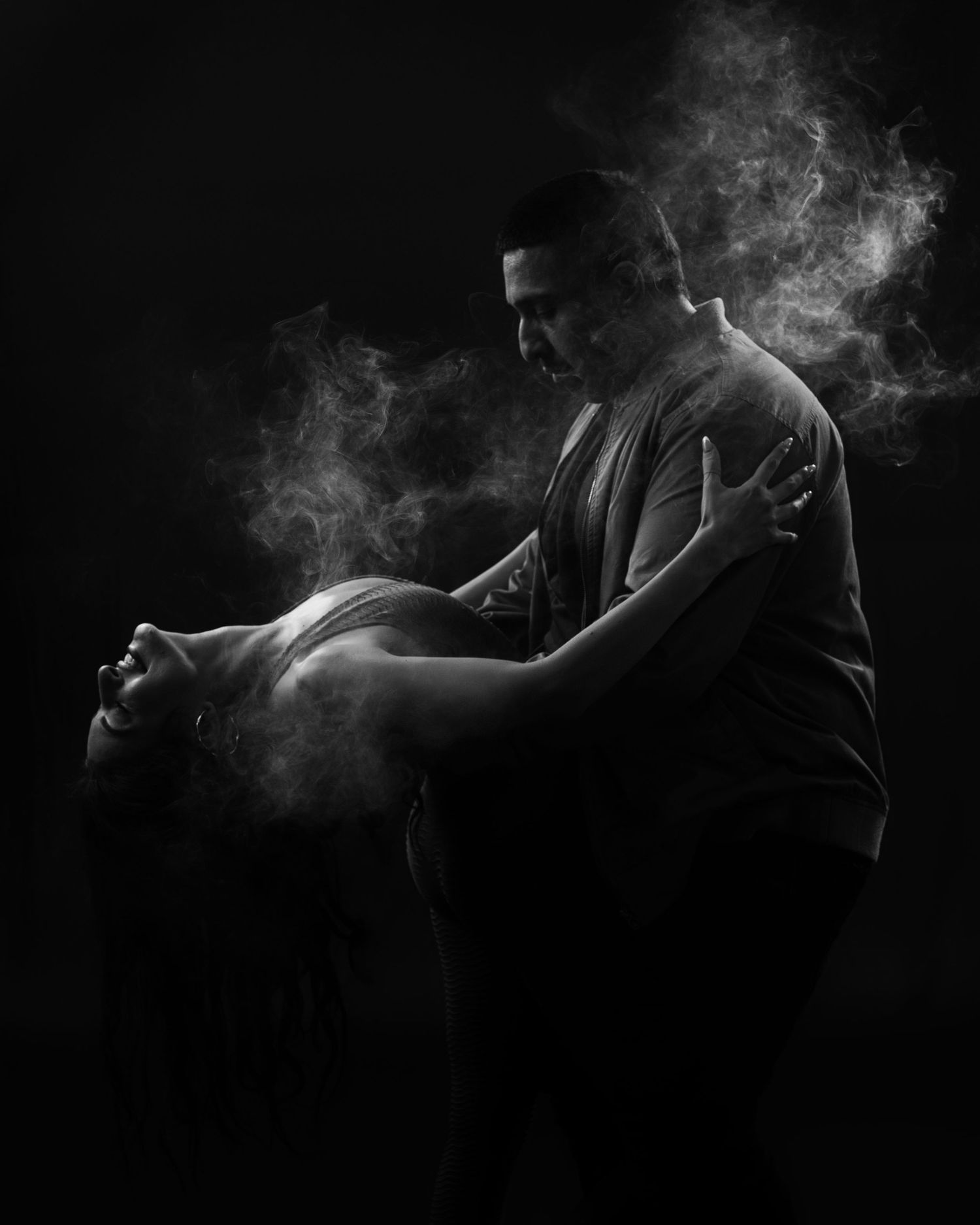 Artistic black and white dance photo with atmospheric smoke effects.