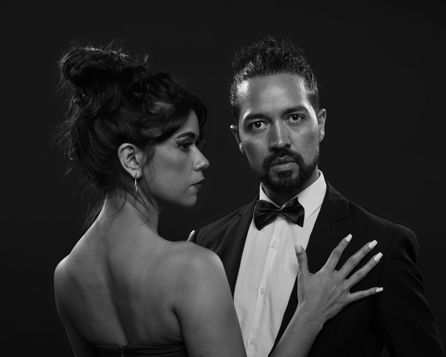Dramatic black and white portrait of a couple in formal evening wear.