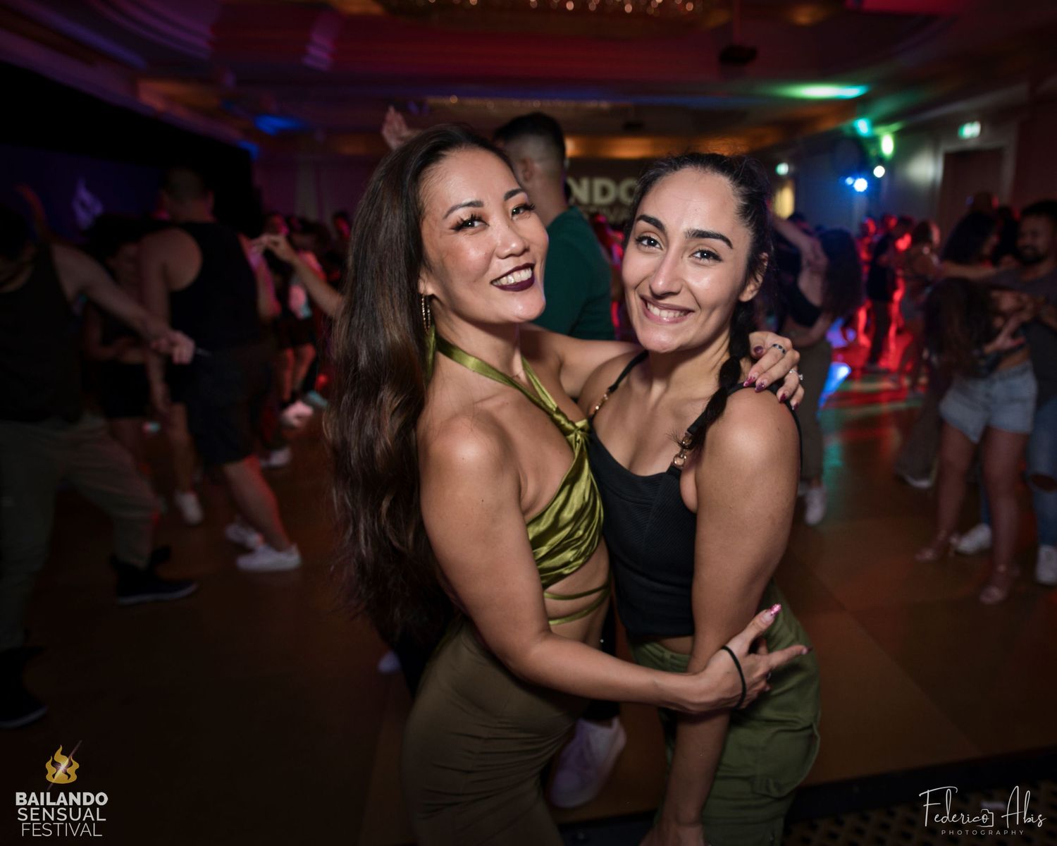 Dance partners sharing a joyful moment on the dance floor with colorful lighting.