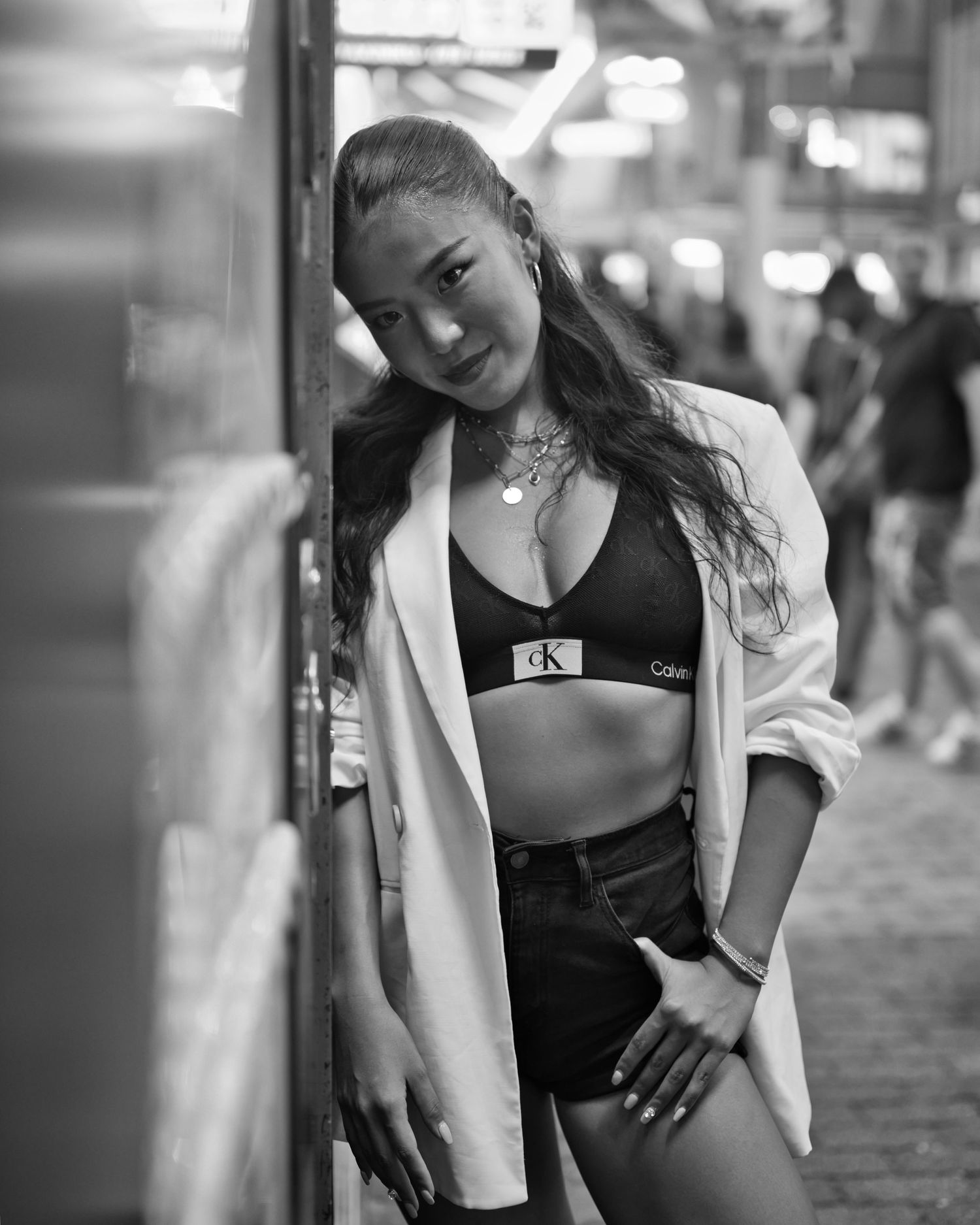 A black and white urban fashion portrait against a city wall.