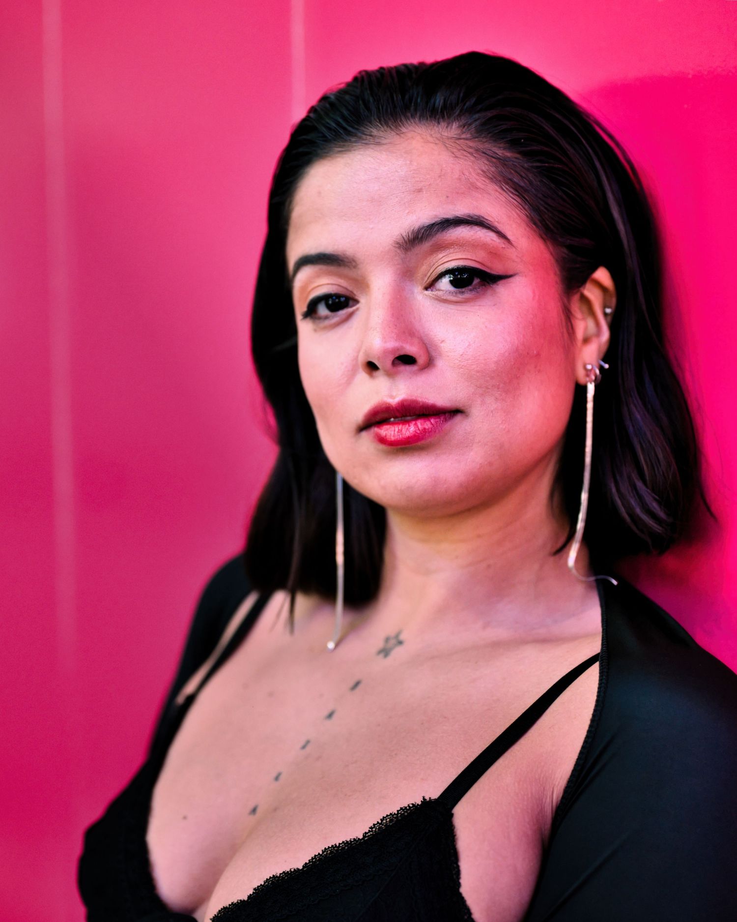 Portrait with dramatic pink lighting against vibrant background.