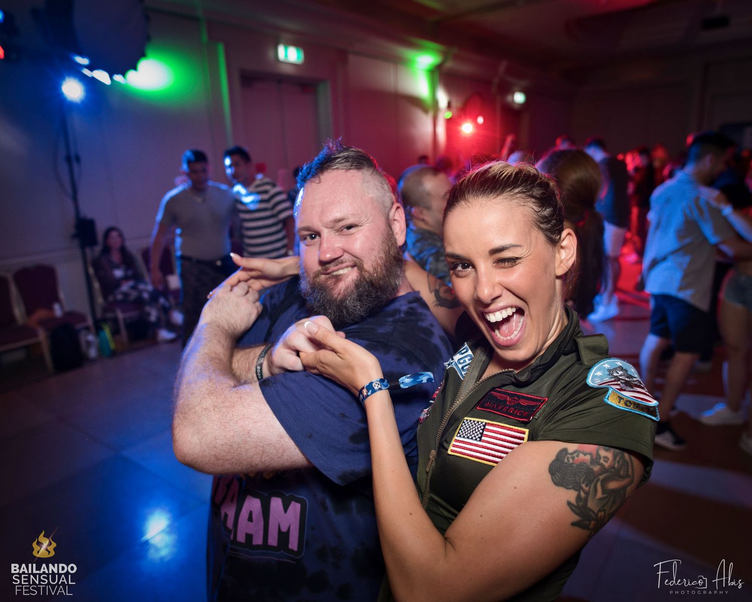 Energetic dancers having fun at a party with colorful lighting and festive atmosphere.