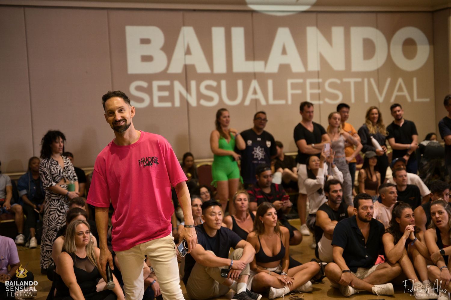 Dance instructor teaching at the Bailando Sensual Festival with audience seated in background.